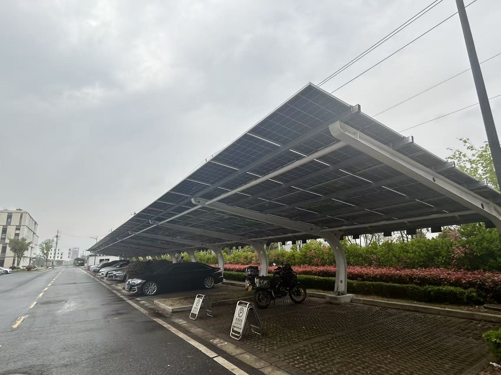 Solar modules covering the steel parking canopy in Danyang, with vehicles parked underneath